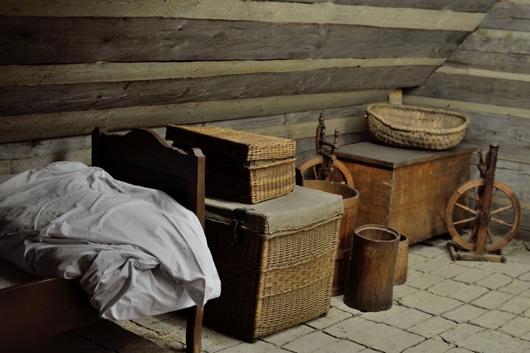 Old village fairytale attic with spinning wheels, old bed and chests